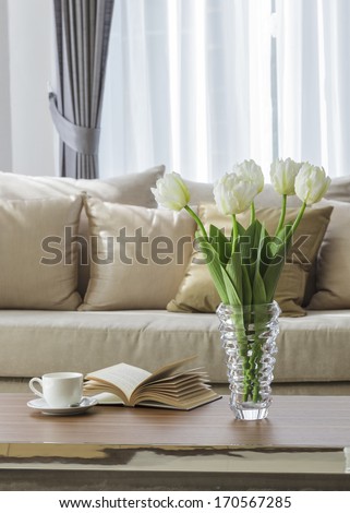 Living room sofa with coffee table book and flower