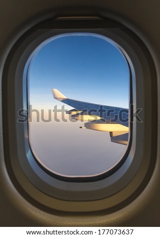 Plane window with sky cloud background