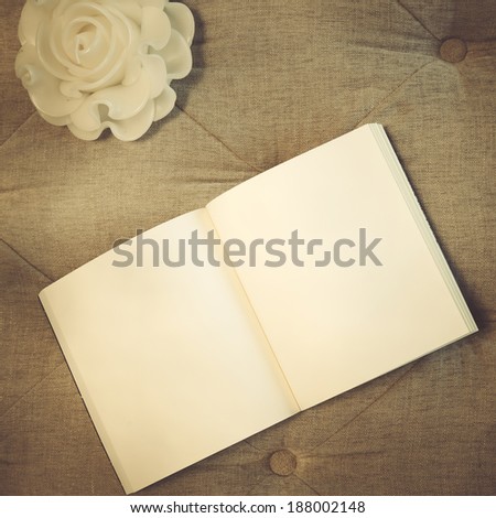 Blank book with candle with vintage filter effect