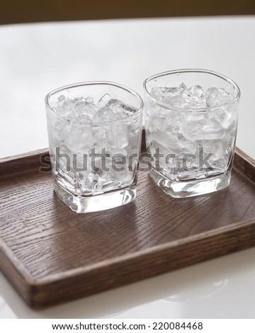Glass of Ice on Wood Tray on Table Coffee Shop