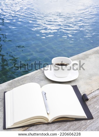Coffee and Book with Pen by Swimming Pool Travel Background