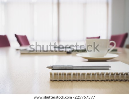 Closeup of notepad in Meeting room interior with coffee and book