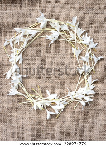 Flower frame design with copy space natural concept.White flowers on sack cloth background.
