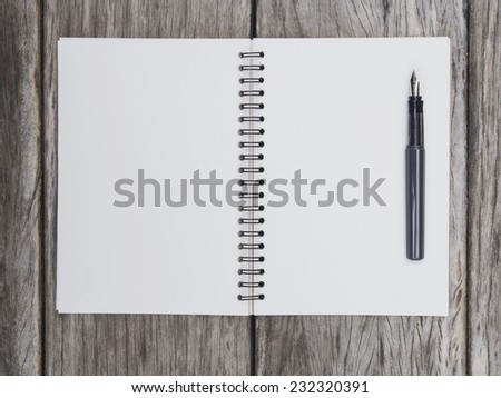 Blank page of book paper with pen on wooden background Top view