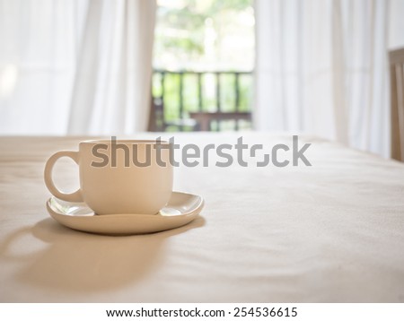 Coffee cup on table with blurred home interior