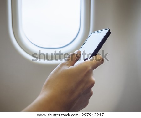 Woman Hand using cell phone in Airplane