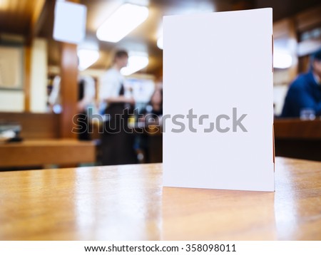 Mock up Menu frame on Table in Bar restaurant cafe Background with people