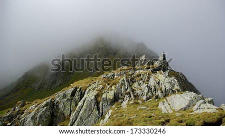 Way to Moldoveanu Peak, Carpathian mountains, Fagaras, Romania. Beautiful landscape with a highest peak in fog, clouds