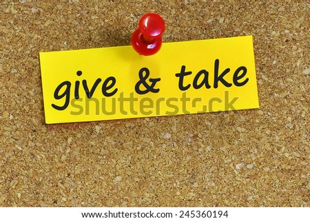 Give and take word on notepaper with brown cork background
