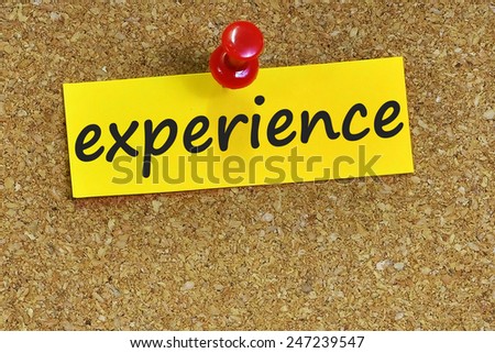 experience word on notepaper with brown cork background