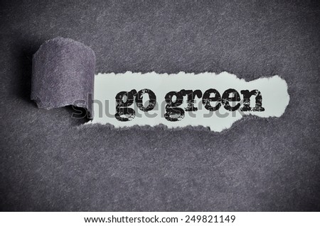 go green  word under torn black sugar paper