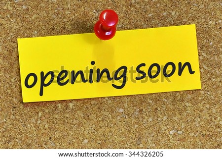 opening soon word on yellow notepaper with cork background.