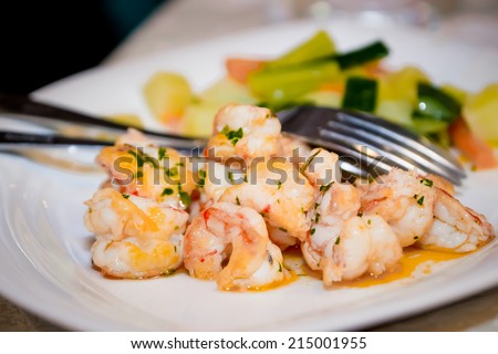 Fried shrimps in sauce with herbs and steamed vegetables