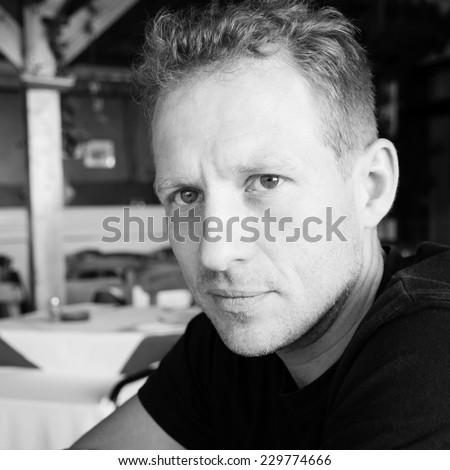 Black and white portrait of handsome man sitting in cafe