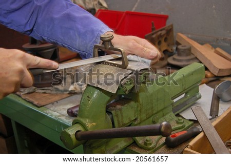 manual worker at work grinding metal in industry
