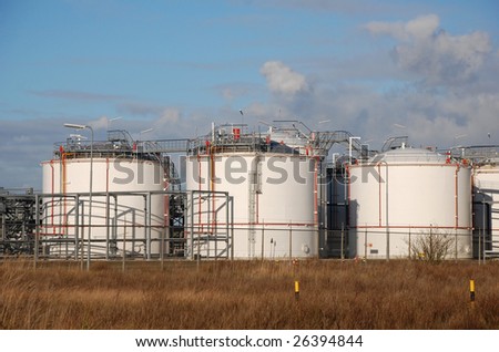 Industrial tanks and piping behind a fence