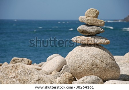 balancing stones on the edge of the ocean