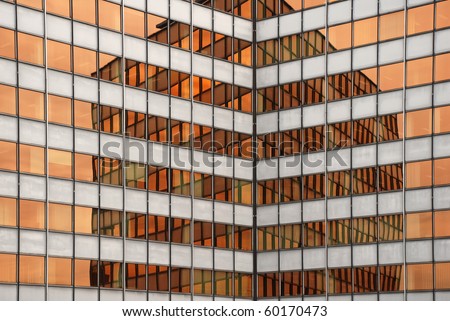 office building reflected in the warm orange windows of another office building