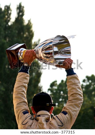 Man raising the winning trophy above his head.
