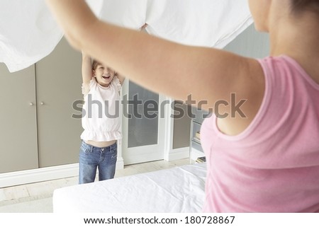 Mother and daughter making the bed in the morning