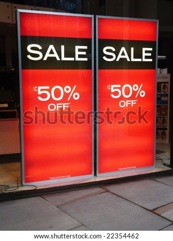 Sale posters in a shop window advertising 50% discount