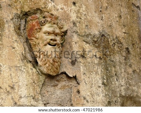 Ancient stone mask on a wall at the ancient Roman city of Herculaneum, which was destroyed and buried during the eruption of Mount Vesuvius in 79 AD