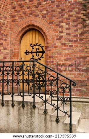 Classic red brick house with wooden door and wrought iron railings