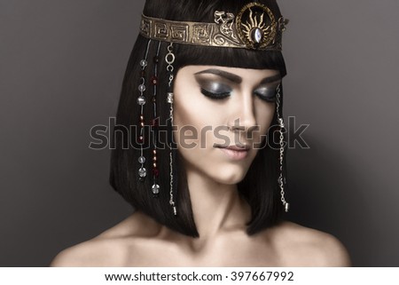 High fashion look. Glamorous closeup portrait of beautiful sexy stylish brunette young woman model with bright  makeup with perfect clean skin with gold jewelery. Cleopatra
