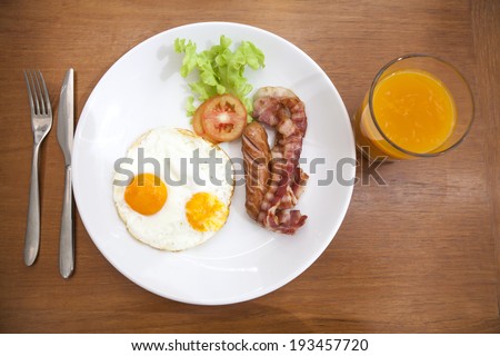 Breakfast sausage bacon, Eggs, Hash Browns, Toast, Orange Juice, water drink, silverware, fork on Dinning table