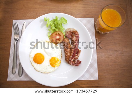 Breakfast sausage bacon, Eggs, Hash Browns, Toast, Orange Juice, water drink, silverware, fork on Dinning table