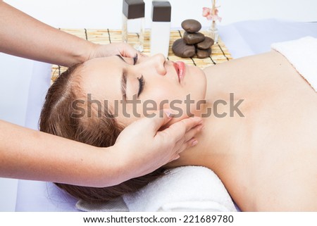 Close-up of young woman receiving facial massage at day spa