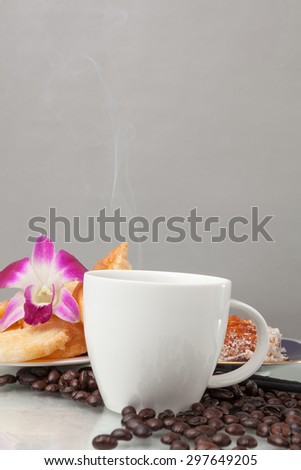 Continental breakfast with assortment of pastries, coffees and flower Orchid in studio shot on coffee beans and white background.