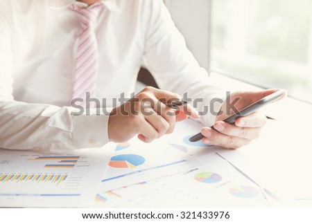 Young businessman working with modern devices, smart phone or mobile phone.