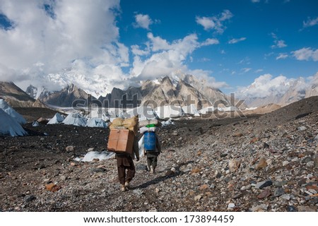 Porters carrying heavy loads in Karakorum mountain range, Pakistan