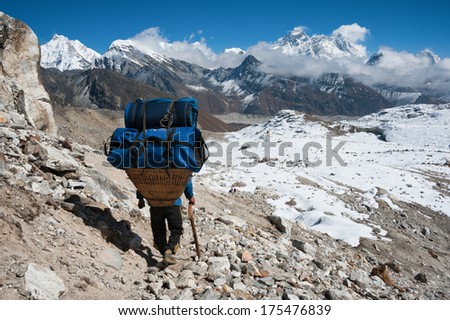 Porter with Mt. Everest  and himalayas, at Renjo mountain pass, Nepal