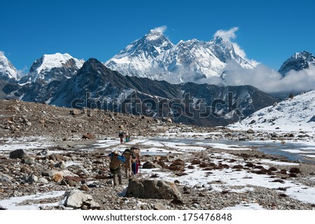 Mt.Everest and a group of porters at Renjo mountain pass, Nepal