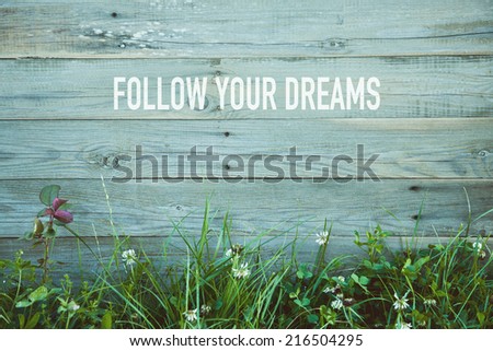 motivational quote FOLLOW YOUR DREAMS on retro wooden background