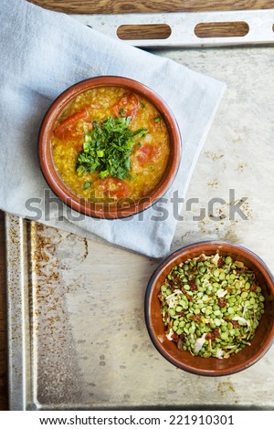 Masur dal indian soup  with tomato, red lentil and onion in bowl on the tray rustic style