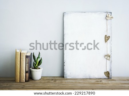 Interior room decoration american or scandinavian style  with books, succulent in the pot and heart shaped garland. Poster with place for text