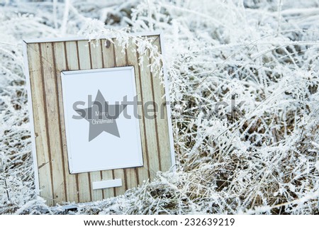 old wooden frame over frozen grass. Merry Christmas