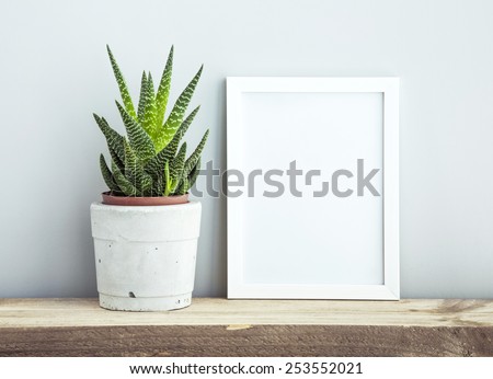 white frame with place for text  with succulent in diy concrete pot. Scandinavian style room interior