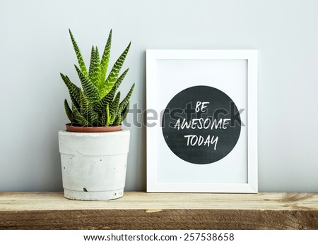 white frame  BE AWESOME TODAY  with succulent in diy concrete pot. Scandinavian hipster style room interior