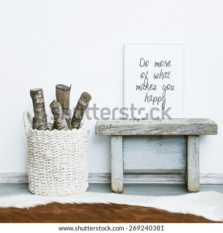 wooden frame DO MORE OF WHAT MAKES YOU HAPPY. Hipster scandinavian style room interior. Basket with firewood and a cow rug on the floor