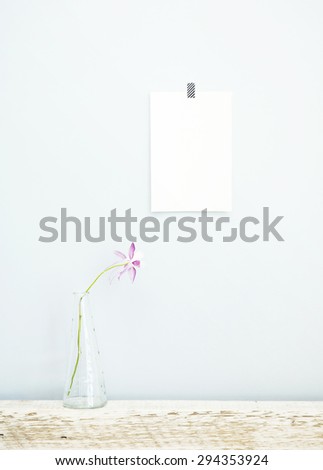 Hipster scandinavian design with pink flower and empty peace of paper on the wall, Mock up.