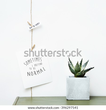 Mock up. Simple garland, postcards  with quote I PRETEND TO BE NORMAL and succulent growing on concrete pot. Hipster scandinavian home interior decoration.