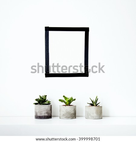 Scandinavian interior design. Hipster motivational mock up with cactus and succulents in concrete pot. Washi tape wall and pot decoration. Frame. Place for text.