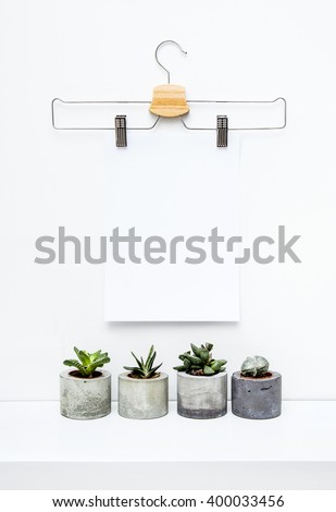 Mock up. Scandinavian hipster interior design.  Hanger with empty poster and four succulents planters. Place for text.