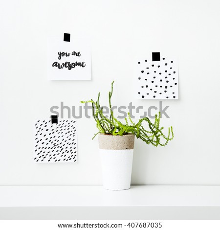 Scandinavian hipster interior design. Note papers on the wall with quote YOU ARE AWESOME and simple hand patterns with succulent or cactus