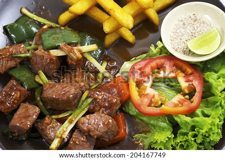 Diced Beef, Delicious grilled beef meatball served on a white plate with tomato and lettuce with a fork in the foreground