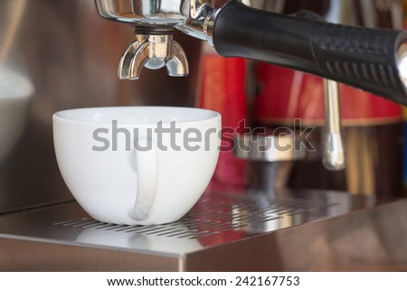 close up of coffee machine makes coffee and white cup